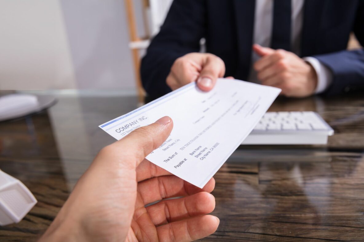 man handing over check