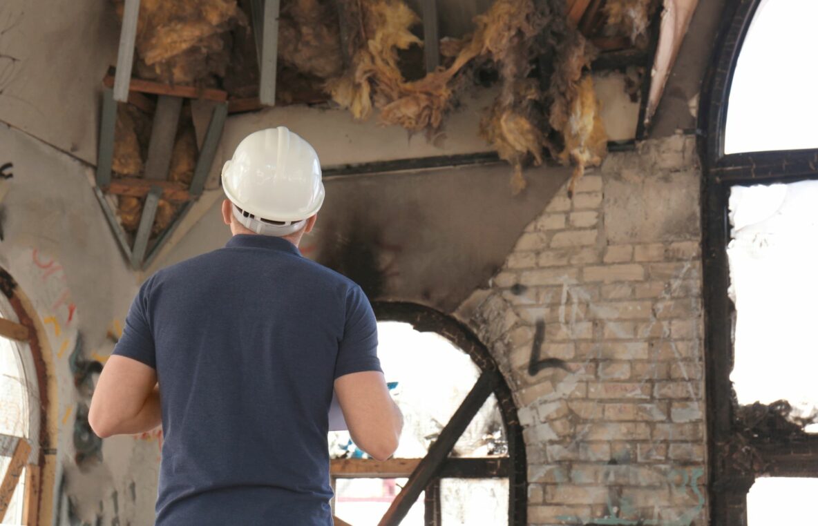 man in hard hat reviewing fire damage