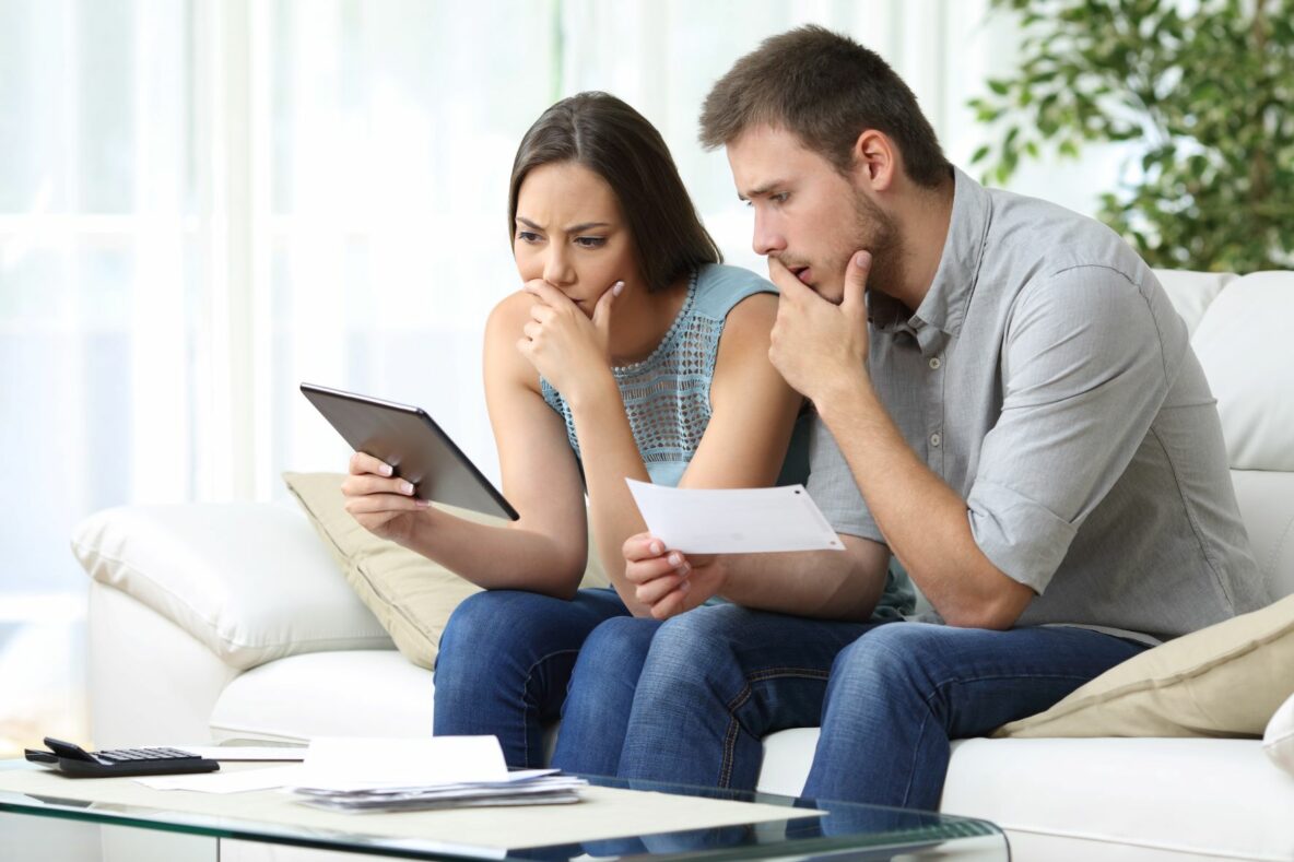 couple with confused expression looking at tablet